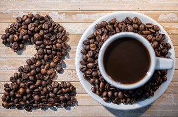 cup of coffee and beans on wooden background