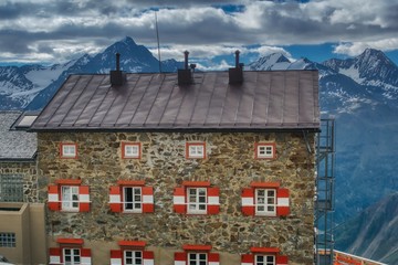 view of a mountain shelter on the background of the alpine peaks, characteristic white and red shutters of the Austrian mountain chalets, hiking and climbing in Austrian Tyrol
