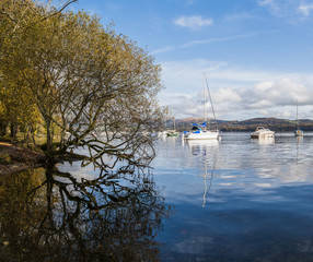 A multi image panorama of small boats moored tothe edge of Lake Windermere, seen in October 2019 in Cumbria.