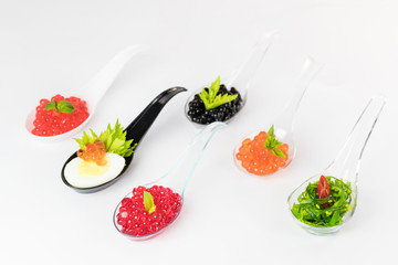 Molecular cuisine caviar elements shot closeup of a plastic buffet table spoon.