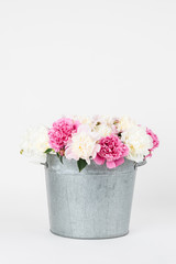 Bouquet of peonies in a metal bucket