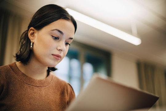 Low angle view of teenage girl using laptop in classroom
