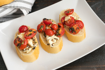 Bruschetta Topped with Baked Feta, Grape Tomatoes and Fresh Herbs