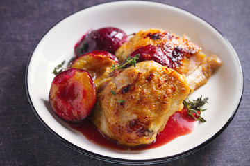 Baked chicken and plums in ginger, honey and red wine sauce with thyme. Horizontal image