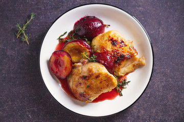 Baked chicken and plums in ginger, honey and red wine sauce with thyme. View from above, top view
