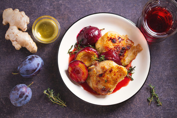 Baked chicken and plums in ginger, honey and red wine sauce with thyme. View from above, top view