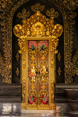 Beautiful golden hindu cultural artwork in the door and doorway inside a traditional Bali dwelling