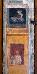 Winged Amorino leads a fish-drawn chariot, a figure of divinity of ancient Rome in Pompeii. Pompeii was destroyed by the volcanic eruption of Vesuvius in 79 BC