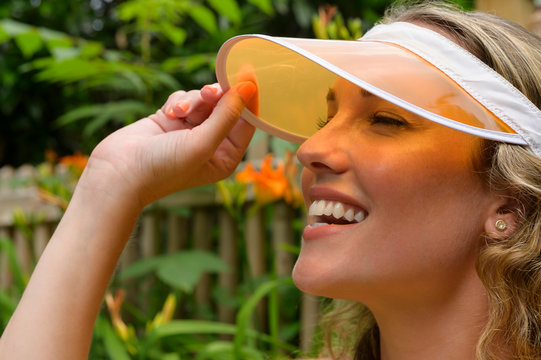 Smiling young woman wearing orange visor