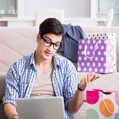 Young man buying clothing online and running blog