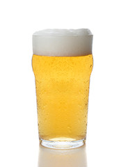 A cold foamy glass of beer isolated on white.