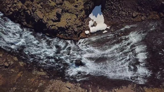 Aerial, screwdriver, drone shot, rising over a waterfall, near the Dynjandi falls, on a partly sunny day, in West fjords, Iceland
