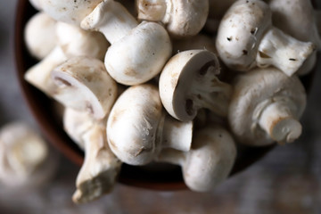 Fresh champignon mushrooms in a bowl. Raw mushrooms. Selective focus. Macro.