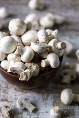 Fresh champignon mushrooms in a bowl. Raw mushrooms. Selective focus. Macro.