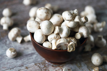 Fresh champignon mushrooms in a bowl. Raw mushrooms. Selective focus. Macro.