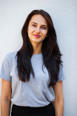 Happy brunette woman in gray t-shirt