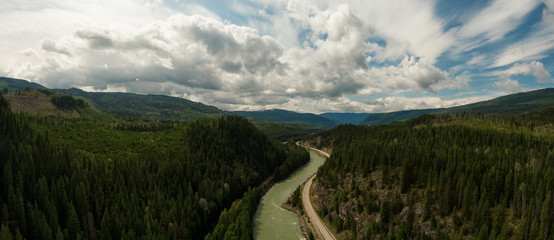 Obraz premium Aerial Panoramic View of a Scenic Highway in the Valley surrounded by Canadian Mountain Landscape. Taken near Clearwater, North of Kamloops, British Columbia, Canada.