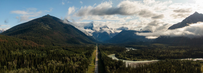 Aerial Panoramic View of Scenic Road in the Beautiful Canadian Mountain Landscape during a sunny and cloudy summer sunrise. Taken near Mt Robson, British Columbia, Canada.