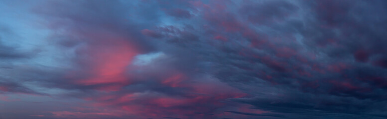 Naklejka na ściany i meble Dramatic Panoramic View of a cloudscape during a dark, rainy and colorful sunset. Taken in British Columbia, Canada.