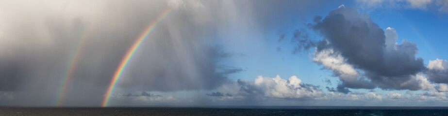 Fototapeta na wymiar Dramatic Panoramic View of a cloudscape during a rainy and colorful morning with a bright double Rainbow. Taken over the Pacific Ocean in Alaska, USA.