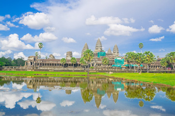 Fototapeta premium Reflection of Angkor Wat temple complex in Cambodia against cloud sky