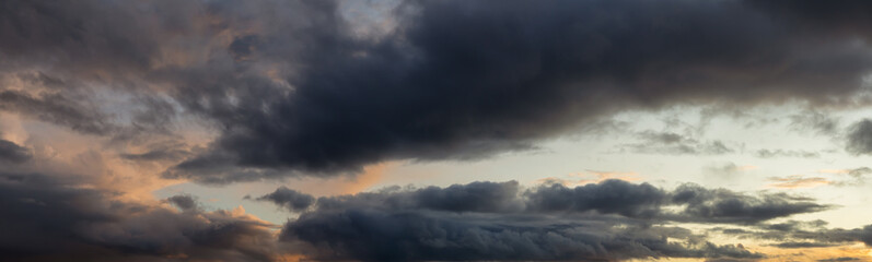 Dramatic Panoramic View of a cloudscape during a dark, rainy and colorful sunset. Taken in Alaska, USA.