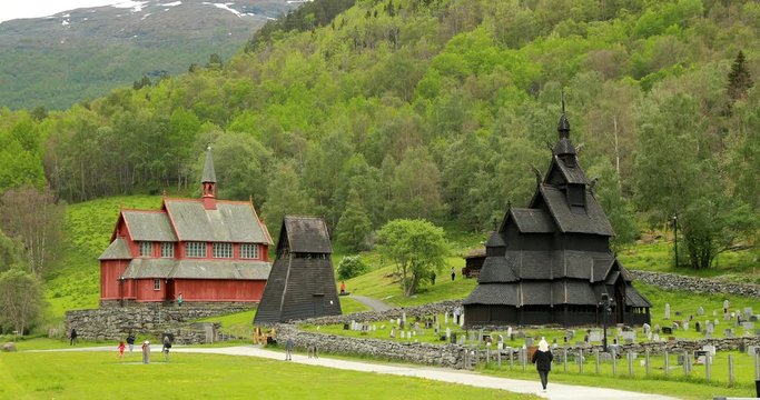 Borgund, Norway. People Walking Near Famous Norwegian Landmark Stavkirke An Old Wooden Triple Nave Stave Church In Summer Day. Zoom, Zoom out. 4K