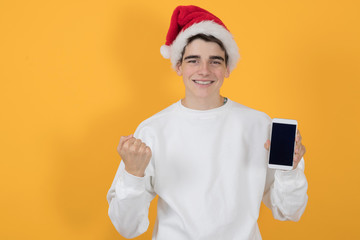teenage man with santa claus hat and mobile phone