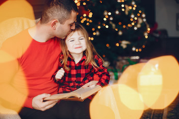 Father in a red sweater. Family sitting near christmas gifts. Little girl near christmas tree