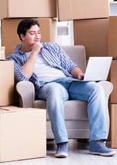 Young man moving in to new house with boxes