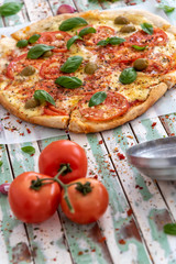 Freshly made wood fired pizza viewed from above on rustic turquoise boards