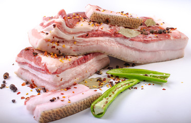 Pork belly fresh meat with spices preparation for salting on a white background