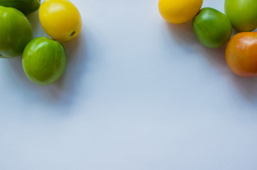 Yellow and green tomatoes on a white background. Vegetable background with blank space for text