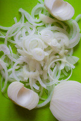 Sliced ​​onions on a green background. ingredient for soup
