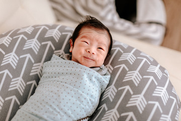 Cute asian baby boy lying on nursing pillow
