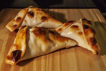 Sfiha, kind of pie like originating in Syria and Lebanon and widely consumed in all the world, on rustic wooden table.