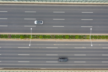 Aerial shot of two cars on opposite directions on a city highway