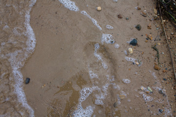 Wet sand with stones and water. Relax on the beach of Vladivostok. copy space, top view