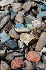 Stones on the shore by the sea. Sea shore with colored stones.