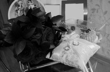 Wedding arrangement bouquet of roses and rings on the pillow, with an empty frame. copy space, top view, flat lay, background with blank space for text