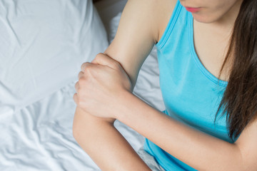 Closeup of woman holding her arm pain. Suffering painful caused by injury or overuse.