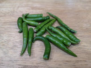 Spicy green peppers, isolated on a wooden floor