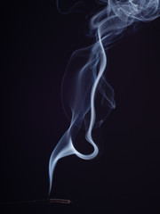 Steam of swirling white smoke, isolated on black background, close up view. Abstract background of burning incense, brush effect. Eastern fragrance for meditation and relaxation