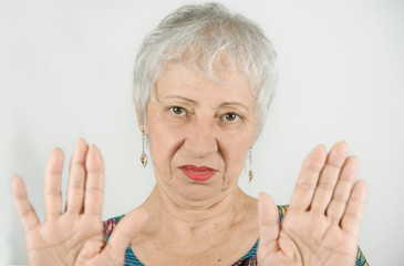 Mature caucasian woman with an angry expression making stop hand sign palm gesture. Hold on, Stop