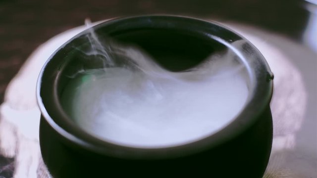 Witch's Cauldron bubbling with green potion in a spooky halloween scene. Dry ice was used for the practical effect.