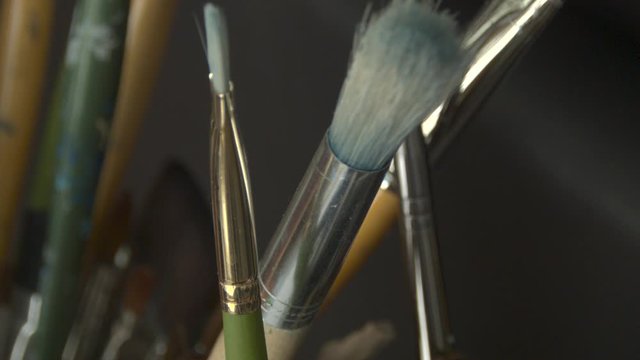 Paint brushes sitting in a mug, ready to be used.