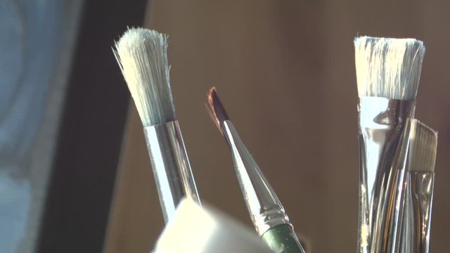 Paint brushes sitting in a mug, ready to be used.