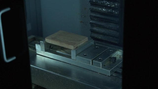 3 axis desktop CNC mill tool moves down into wood stock end mill tool spinning