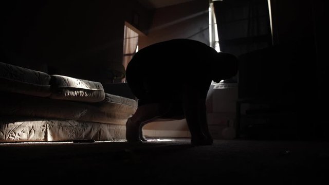 a depressed man falls on floor in his apartment to cry and pray