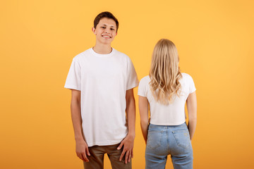 Funny young couple on orange background